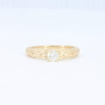 Load image into Gallery viewer, Delicate yellow gold ring with intricate floral engravings and a sparkling round diamond centerpiece.