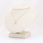Load image into Gallery viewer, Gold chain necklace with a sparkling cubic zirconia pendant on a display stand. Elegant and stylish jewelry piece.