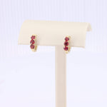 Load image into Gallery viewer, Gold hoop earrings featuring three red gemstones, perfect for adding a touch of elegance to any outfit.