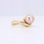 Load image into Gallery viewer, Gold twist ring featuring a luminous pinkish-pearl centerpiece, elegant and modern design, perfect for any occasion.