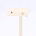 Load image into Gallery viewer, Rose gold stud earrings crafted from high-quality metal on a soft display stand. Elegant and timeless design.