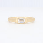 Load image into Gallery viewer, Elegant gold ring featuring a rectangular emerald-cut diamond, showcasing a minimalist design for a timeless look.