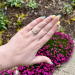 Load image into Gallery viewer, Elegant silver engagement ring with a trio of sparkling diamonds, showcased on a hand adorned with colorful nail art.