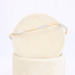 Load image into Gallery viewer, Elegant gold and silver bracelet with textured links, showcasing a modern design on a soft beige display.