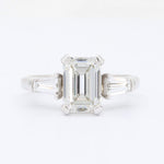 Load image into Gallery viewer, Elegant white gold engagement ring with an emerald-cut diamond center and tapered baguette side stones.
