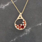 Load image into Gallery viewer, Gold pendant necklace featuring red and orange gemstones with a sparkling design on a delicate chain.