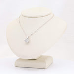 Load image into Gallery viewer, Silver necklace with a sparkling crystal pendant, displayed on a soft beige bust. Elegant and timeless design.