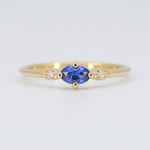 Load image into Gallery viewer, Gold gemstone ring with a central oval blue sapphire and two sparkling diamonds. Elegant and timeless design.