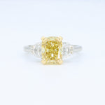 Load image into Gallery viewer, Radiant yellow cushion cut diamond ring with side white diamonds, set in gold and platinum, elegant and modern design.