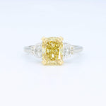 Load image into Gallery viewer, Yellow cushion-cut diamond ring with white side stones, set in gold and platinum band, elegant and modern design.