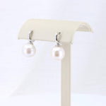 Load image into Gallery viewer, Elegant pearl drop earrings in white with silver-tone settings, perfect for any formal or casual occasion.