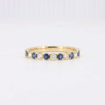 Load image into Gallery viewer, Gold band ring featuring alternating blue sapphires and white diamonds, classic design for elegant jewelry collections.