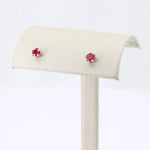 Load image into Gallery viewer, Gold stud earrings with round ruby gemstones, perfect for elegant or casual looks.