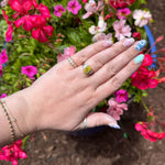 Load image into Gallery viewer, Gold and silver rings with a yellow gemstone, worn on a hand against a backdrop of vibrant pink flowers.
