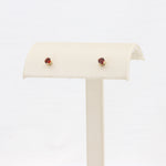 Load image into Gallery viewer, Gold stud earrings with deep red gemstones, elegant and versatile for any occasion.