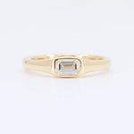 Load image into Gallery viewer, Elegant yellow gold ring featuring a center emerald-cut diamond, perfect for engagement or special occasions.
