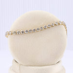 Load image into Gallery viewer, Gold tennis bracelet featuring sparkling round cubic zirconia stones on a plush display. Elegant and timeless jewelry piece.