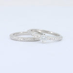 Load image into Gallery viewer, Elegant white gold wedding ring set featuring a diamond accent and intricate floral engraving. Perfect for engagement.