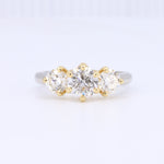 Load image into Gallery viewer, Three-stone diamond ring featuring round cut diamonds set in yellow gold with a sleek white gold band.