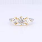 Load image into Gallery viewer, Three-stone diamond engagement ring in white gold with yellow gold prongs, featuring brilliant-cut round diamonds.