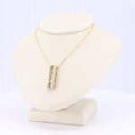 Load image into Gallery viewer, Gold chain necklace with rectangular pendant featuring blue gemstones, elegant and modern design.