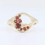 Load image into Gallery viewer, Gold ring with red gemstones and diamond accents in a modern, curved design.