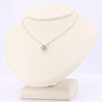 Load image into Gallery viewer, Gold chain necklace with a single purple gemstone pendant on a display bust. Elegant and timeless design.