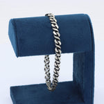Load image into Gallery viewer, Men's silver stainless steel chain bracelet on a blue velvet display stand, sleek and stylish design.