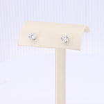 Load image into Gallery viewer, Elegant silver stud earrings featuring sparkling round clear crystals on a minimalist cream display stand.