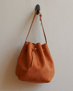 Load image into Gallery viewer, Tan Leather Tie Bucket Bag with Adjustable Strap and Yellow Hardware