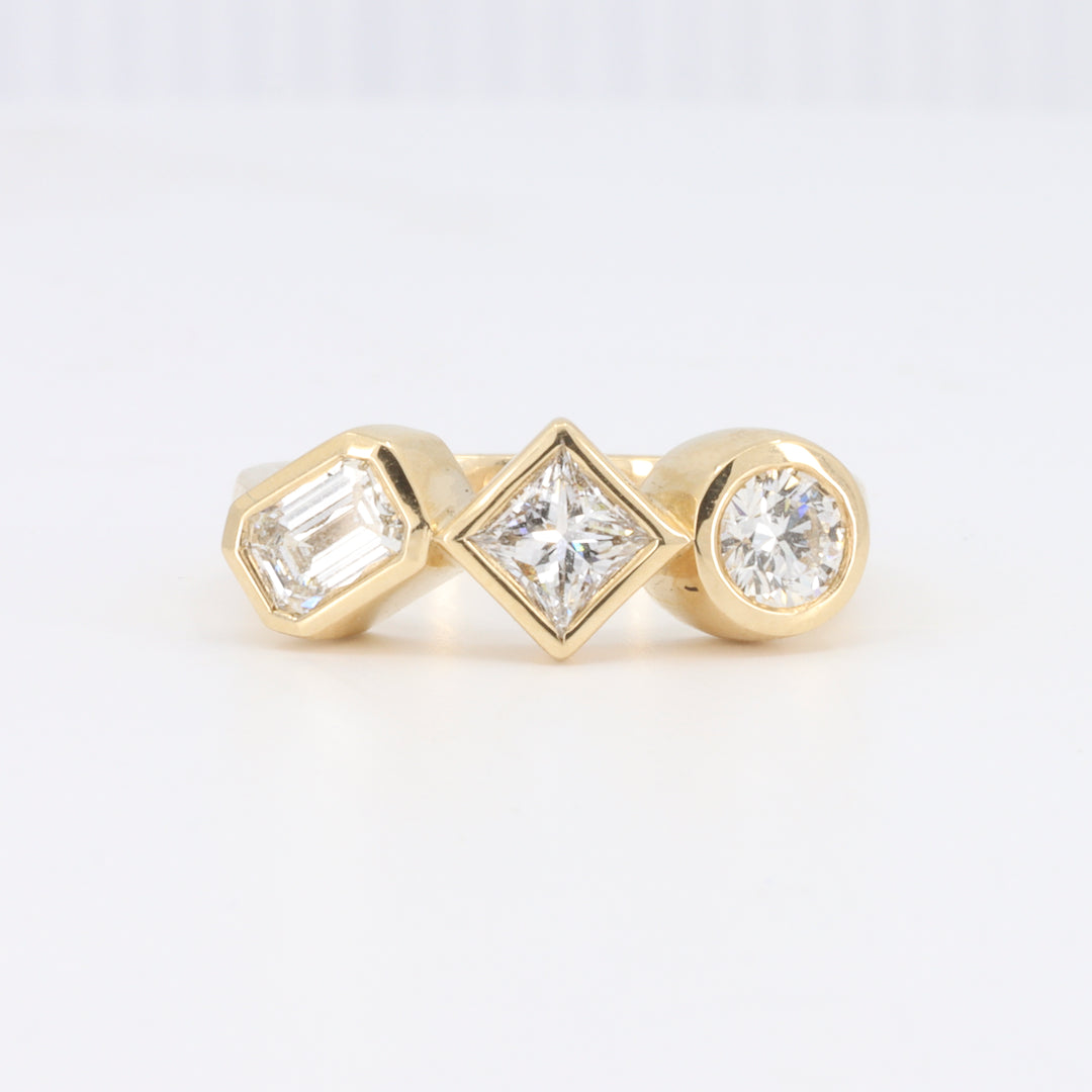 Bezel Set Three Stone Engagement Ring with an Emerald Cut, Round and Princess Cut Diamond