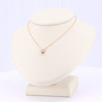 Load image into Gallery viewer, Rose gold chain necklace with sparkling cubic zirconia pendant on a display bust. Elegant and stylish jewelry piece.