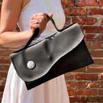 Load image into Gallery viewer, Asymmetrical matte black leather clutch bag with white metal hardware