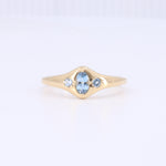 Load image into Gallery viewer, Gold vintage-style ring featuring a central oval aquamarine and two smaller round aquamarines on a sleek band.