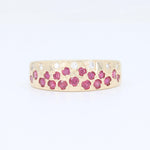 Load image into Gallery viewer, Gold band ring featuring ruby and diamond accents in a floral design. Elegant and eye-catching statement piece.