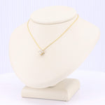 Load image into Gallery viewer, Gold necklace with a cubic zirconia pendant on a cream-colored display. Elegant and modern jewelry design.