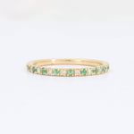 Load image into Gallery viewer, Gold eternity band ring with emerald and diamond accents, featuring a sleek, modern design.