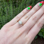 Load image into Gallery viewer, Gold engagement ring featuring a large diamond center stone with smaller accent stones on a delicate band.