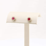 Load image into Gallery viewer, Gold halo stud earrings with red gemstones and sparkling white cubic zirconia accents. Elegant and timeless design.