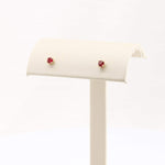 Load image into Gallery viewer, Gold stud earrings with red gemstone accents, featuring a delicate floral design, perfect for everyday elegance.