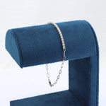 Load image into Gallery viewer, Silver diamond tennis bracelet on a blue velvet display stand. Elegant and modern design with a secure chain clasp.