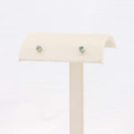 Load image into Gallery viewer, Elegant gold stud earrings with sparkling blue gemstones, perfect for any occasion.