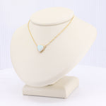 Load image into Gallery viewer, Gold triangle pendant necklace featuring an iridescent opal stone on a delicate chain. Elegant and stylish accessory.