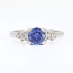 Load image into Gallery viewer, Sterling silver ring featuring a round blue sapphire center stone surrounded by sparkling white diamonds.