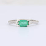 Load image into Gallery viewer, Emerald cut emerald ring in polished white gold, accented with sparkling diamonds on each side.