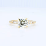 Load image into Gallery viewer, Gold engagement ring with a round diamond centerpiece and three smaller diamonds on a sleek band.