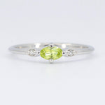 Load image into Gallery viewer, Elegant silver ring featuring a bright green peridot center stone and two small diamond accents, vintage-inspired design.