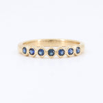 Load image into Gallery viewer, Elegant gold ring with navy blue sapphires, featuring a modern understated design, perfect for stacking or everyday wear.