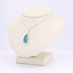 Load image into Gallery viewer, Silver chain necklace featuring a teardrop opal pendant with vibrant blue and green hues, stylishly displayed on a bust.