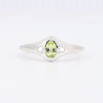 Load image into Gallery viewer, Sterling silver ring featuring an oval green peridot and two round white diamonds, elegant and modern design.